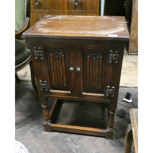 119 - An Old Charm oak bedside cabinet with linen fold panel doors (top is marked)