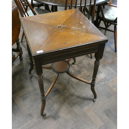 142 - An Edwardian walnut envelope card table on reeded style legs with under tier, 22