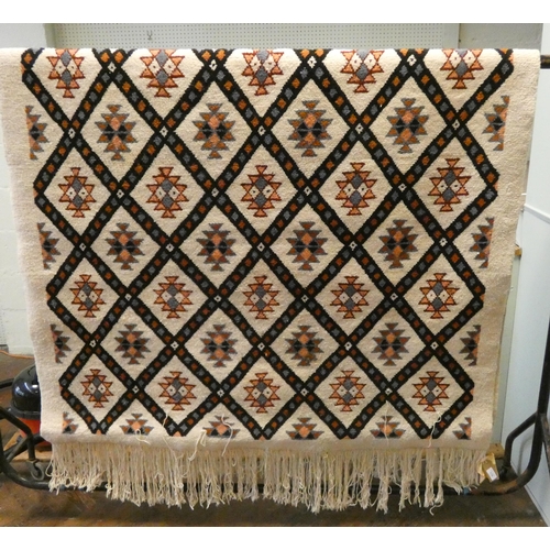 179 - A Tunisian cream and geometrically designed wool pile rug, 8'6 X 5' approximately with fringed ends