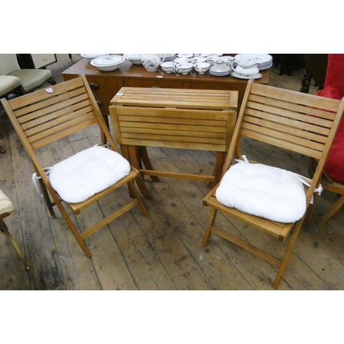 84 - A gate leg style outdoor teak slatted garden table and two matching folding chairs with cushions