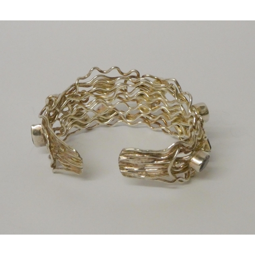 457 - A wide bespoke made silver and wirework amethyst set bangle. 31mm wide, gross weight 58 grams