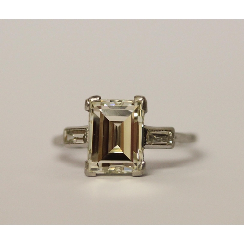 450 - An Art Deco solitaire diamond ring, the emerald cut diamond weighing approximately 3 carats, claw se... 