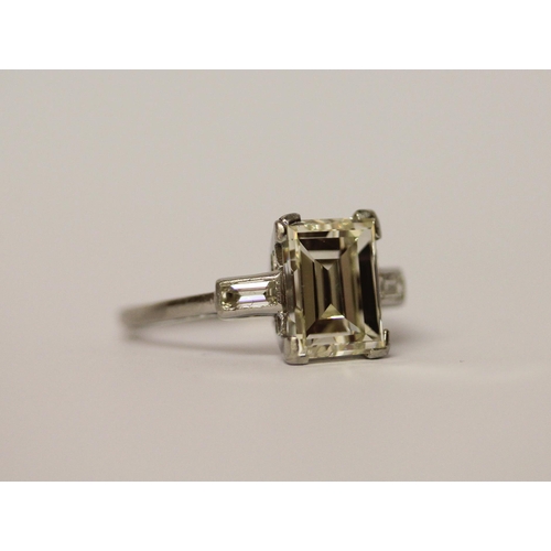 450 - An Art Deco solitaire diamond ring, the emerald cut diamond weighing approximately 3 carats, claw se... 