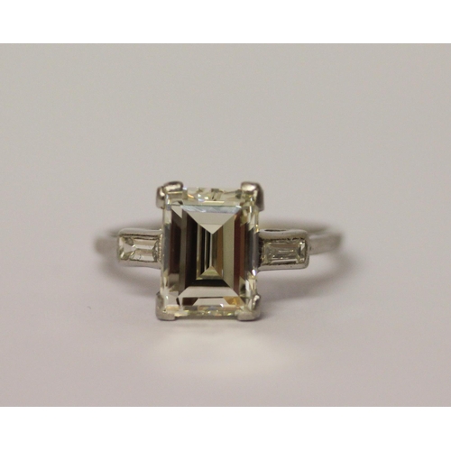 450 - An Art Deco solitaire diamond ring, the emerald cut diamond weighing approximately 3 carats, claw se... 