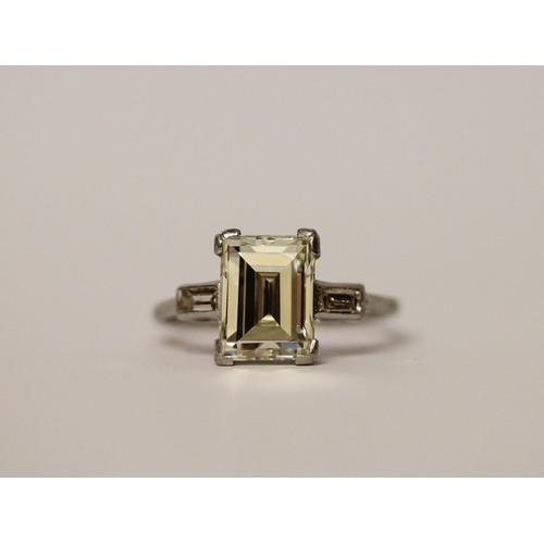 450 - An Art Deco solitaire diamond ring, the emerald cut diamond weighing approximately 3 carats, claw se... 