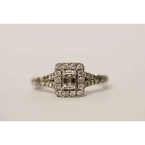 383 - A platinum and diamond ring, with an emerald cut diamond to the central rectangular panel, surrounde... 