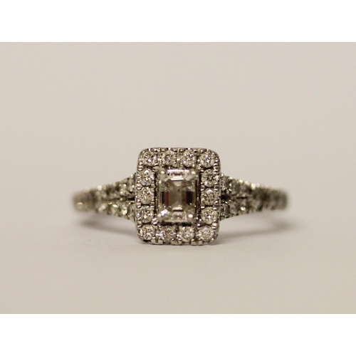 383 - A platinum and diamond ring, with an emerald cut diamond to the central rectangular panel, surrounde... 