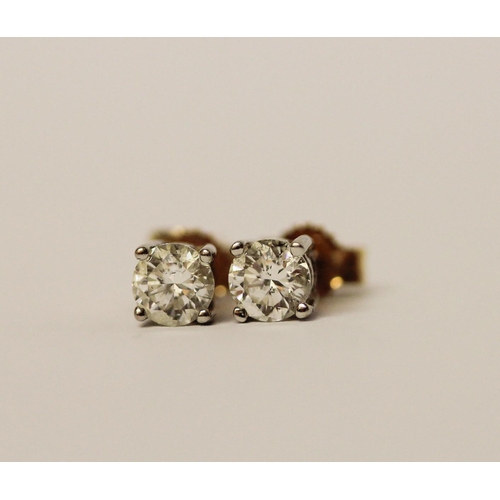 386 - A pair of solitaire diamond ear studs, the brilliant circular cut diamonds in four claw settings to ... 