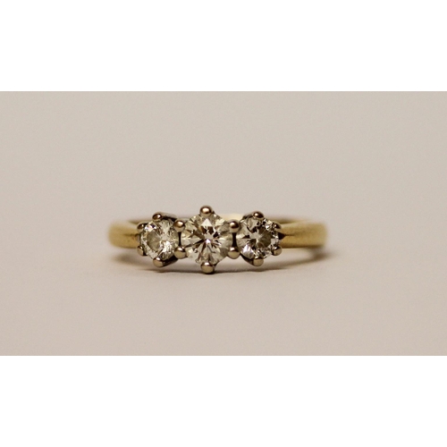 446 - A three stone diamond ring, three brilliant cut circular diamonds on an 18ct yellow gold band, Diamo... 