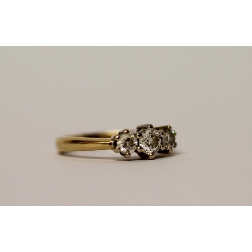 446 - A three stone diamond ring, three brilliant cut circular diamonds on an 18ct yellow gold band, Diamo... 