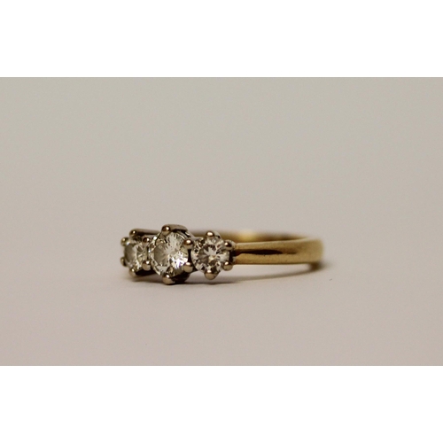 446 - A three stone diamond ring, three brilliant cut circular diamonds on an 18ct yellow gold band, Diamo... 