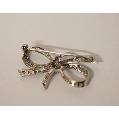 453 - A diamond ribbon bow brooch, set in 18ct white gold, 36mm across, weight 5g, in fitted box