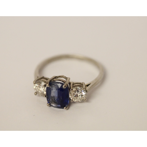 454 - A sapphire and diamond three stone ring, The central oval mixed cut sapphire claw set, flanked betwe... 