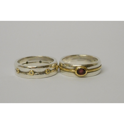 459 - A wide modern silver and garnet band ring and a silver eternity ring, size T, weight 18.8g