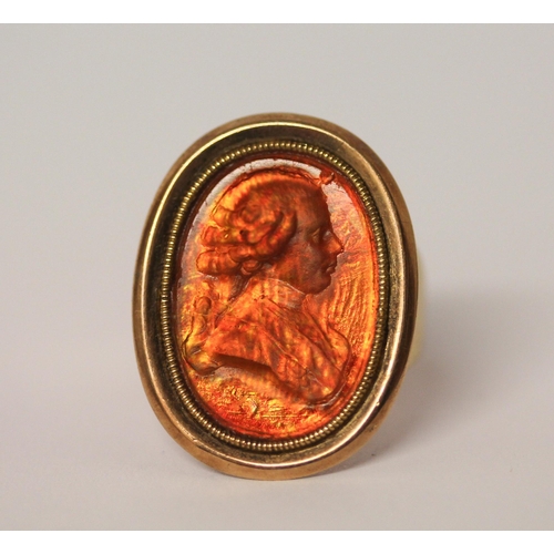 469 - A Georgian intaglio panel ring, the large oval panel carved with a portrait in profile, foiled close... 