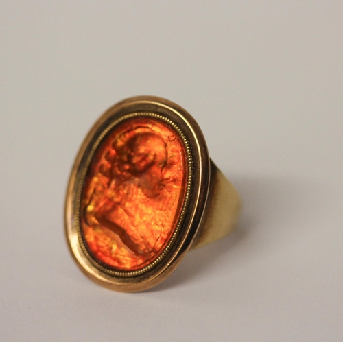 469 - A Georgian intaglio panel ring, the large oval panel carved with a portrait in profile, foiled close... 