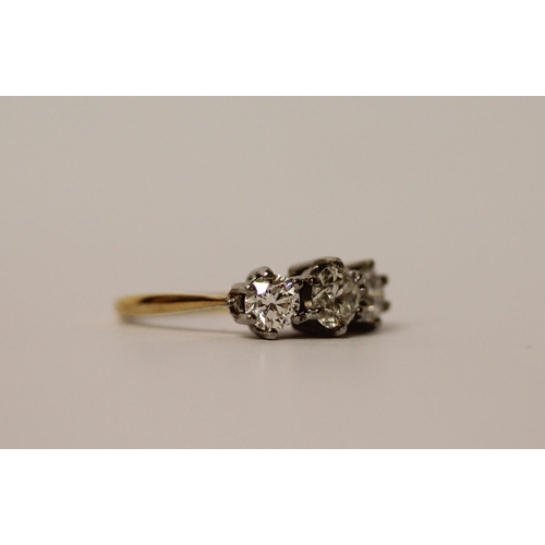 364 - A vintage three stone diamond ring, the three brilliant cut diamonds in claw setting on platinum and... 