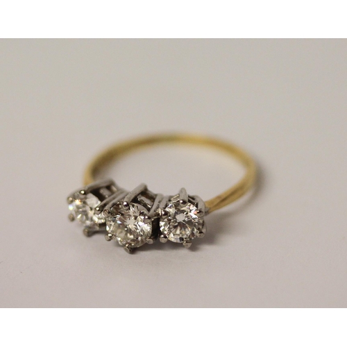 364 - A vintage three stone diamond ring, the three brilliant cut diamonds in claw setting on platinum and... 