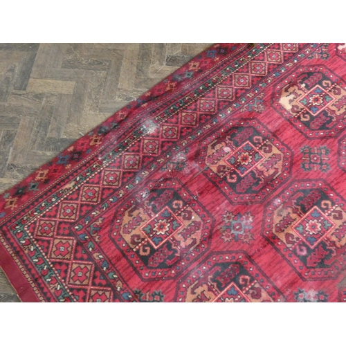 109 - A large red and pattered wool pile rug, 120