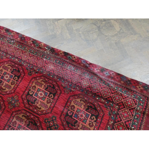 109 - A large red and pattered wool pile rug, 120