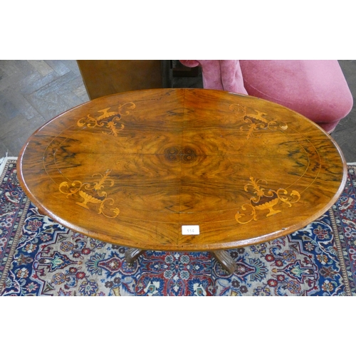 114 - An inlaid walnut oval coffee table on quadruple base