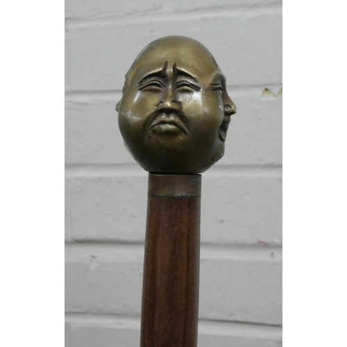 124 - A walking cane with bronze Buddha various faces handle