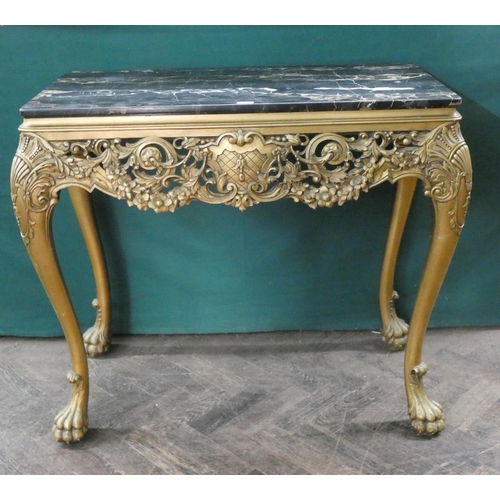 125 - A decorative gilt console table standing on paw feet with black mottled marble top, 34