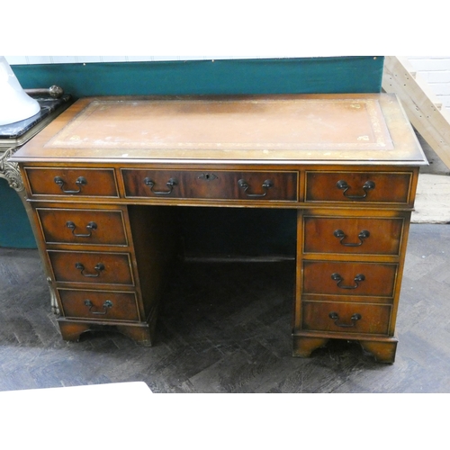 127 - A Georgian style mahogany kneehole pedestal desk fitted nine drawers with inset leather top