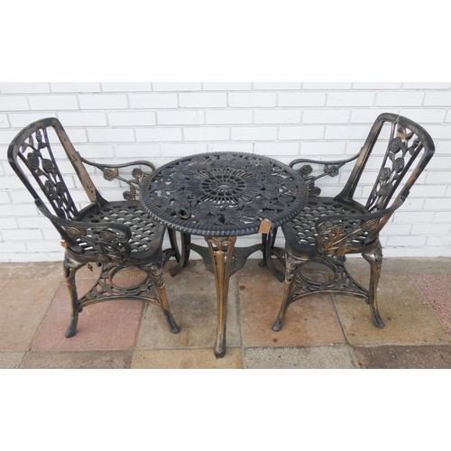 455 - A black painted circular garden table with two matching chairs...