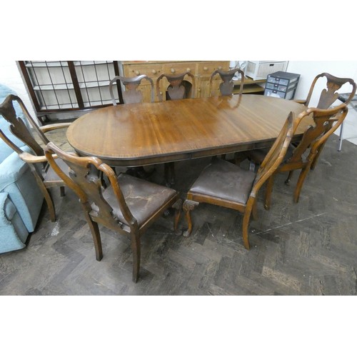 63A - A Georgian oval mahogany extending dining table with centre leaf and eight mahogany shield backed ch...