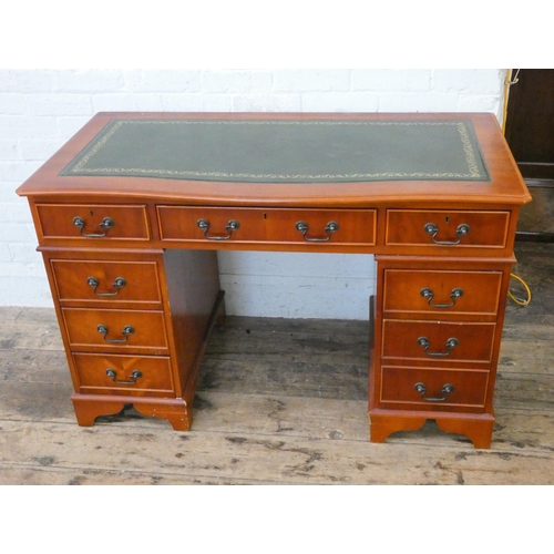 145 - A Georgian style twin pedestal office desk fitted nine drawers with green inset leather top, 4' wide