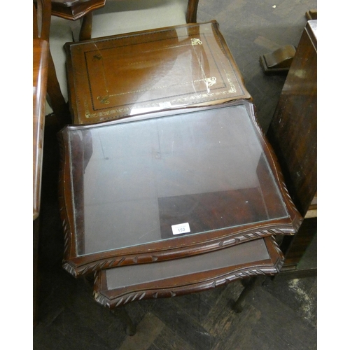 153 - Nest of three mahogany coffee tables with glass tops and two lighter colour coffee tables