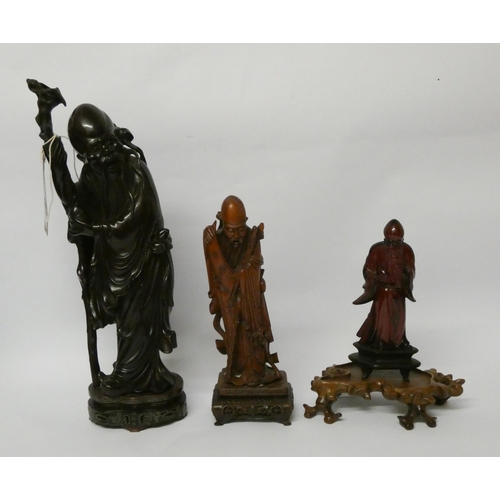 280 - A Japanese root carving of a sage together with two smaller carvings and two hardwood bases, tallest... 