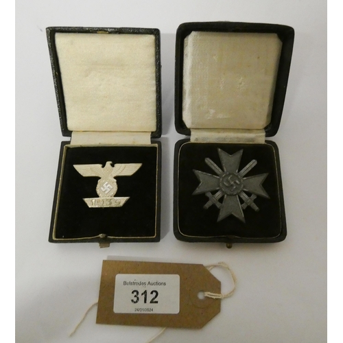 312 - Two boxed Nazi insignia -  the bar for the Iron Cross First Class World War II and the other War Mer... 