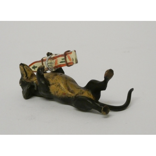 323 - Miniature cold painted novelty bronze of a dachshund carrying skis. 5 cms tall