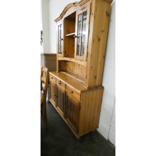 192 - A Pine dining room suite comprising oval table, four ladder back style chairs and a dresser with gla... 