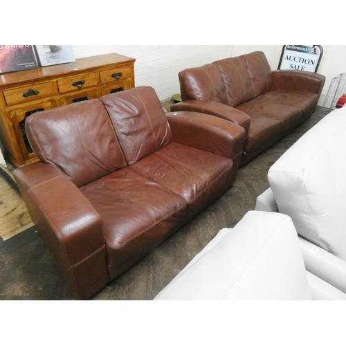 137 - A three seater settee in brown leather and a matching two seater