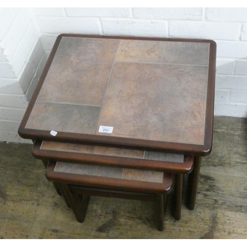 204 - A nest of three teak and brown tile topped coffee tables