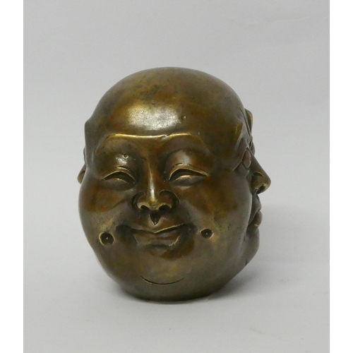 450 - A four sided Buddha head bronze paperweight