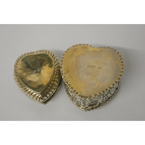 669 - Two hallmarked silver heart shaped trinket boxes with embossed decoration and hinged lids, largest m... 