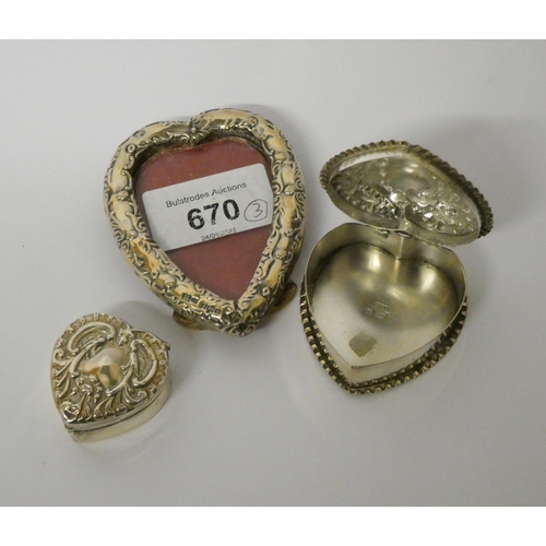 670 - Heart shaped silver photograph frame, 8cms tall together with two heart shaped silver embossed trink... 