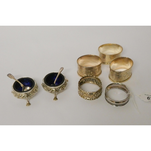 671 - A collection of five silver napkin rings and a pair of silver cauldron shaped salt cellars with blue... 