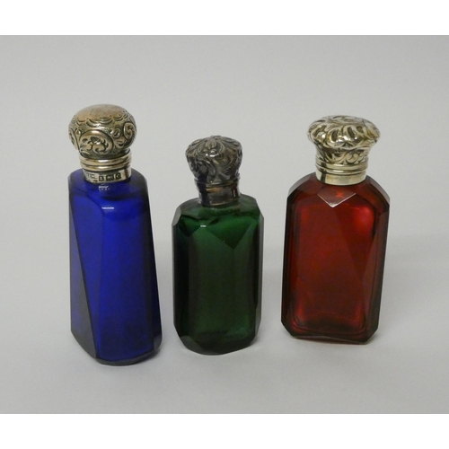 677 - A collection of three 19th century coloured glass scent bottles with hinged silver tops and glass st... 