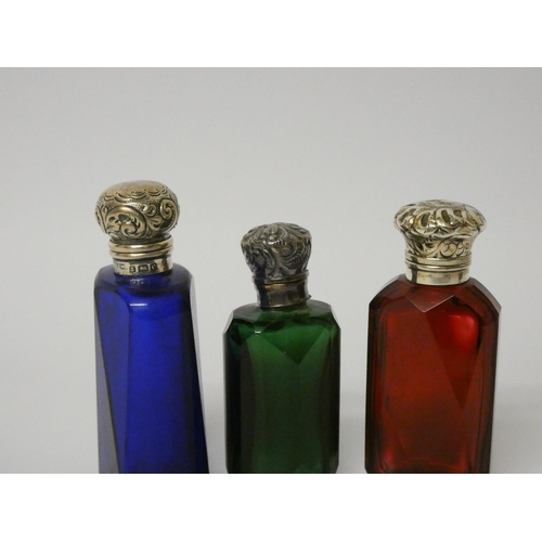 677 - A collection of three 19th century coloured glass scent bottles with hinged silver tops and glass st... 