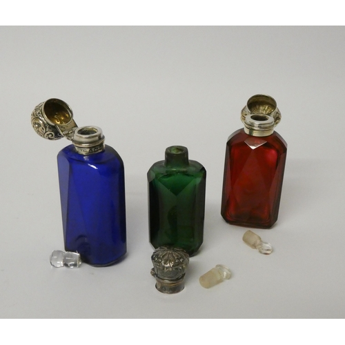 677 - A collection of three 19th century coloured glass scent bottles with hinged silver tops and glass st... 