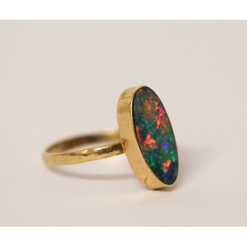 576 - Australian boulder opal oval dress ring, in rub over setting, to 14k  yellow gold band. Size U