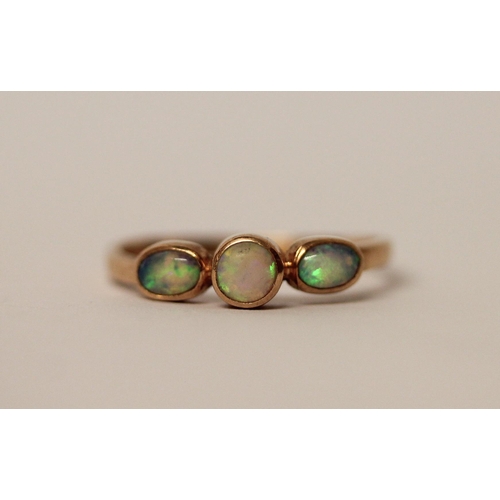 577 - A three stone opal ring, set in rose gold, unmarked but tests as gold. Ring size S