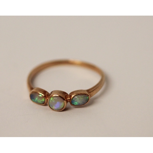 577 - A three stone opal ring, set in rose gold, unmarked but tests as gold. Ring size S