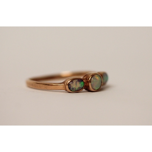 577 - A three stone opal ring, set in rose gold, unmarked but tests as gold. Ring size S