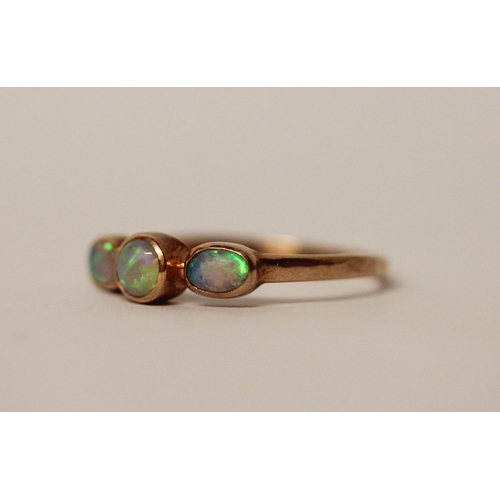 577 - A three stone opal ring, set in rose gold, unmarked but tests as gold. Ring size S